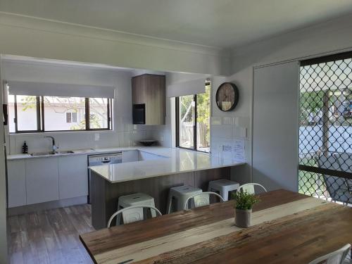 a kitchen with a wooden table and a counter top at Rainbow Stairs in Rainbow Beach