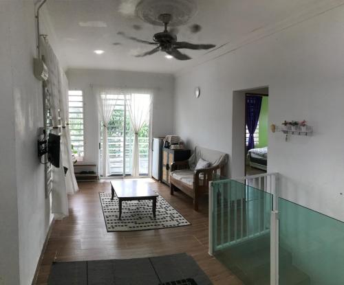 Bendang Homes - Sekinchan Homestay في Kampong Sungai Leman: غرفة معيشة مع مروحة سقف وطاولة