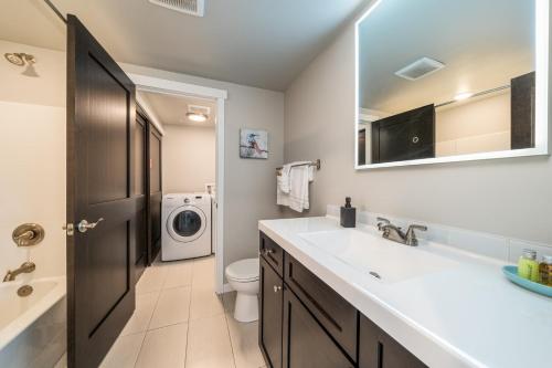 a bathroom with a sink and a washing machine at Marina's Edge Condo walk to restaurants and wineries condo in Manson