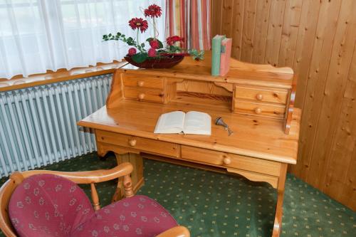 a wooden desk with two chairs and a book at Hotel Zum Löwen - Unteres Wirtshaus in Titisee-Neustadt