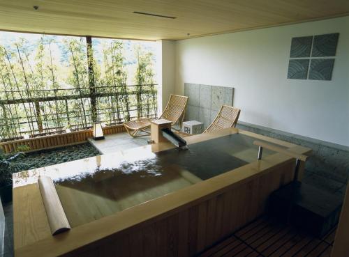 a large bath tub in a room with a balcony at Gora Kadan in Hakone