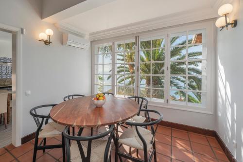 a dining room with a table and chairs and a window at OurMadeira - Vista Grande in Caniço