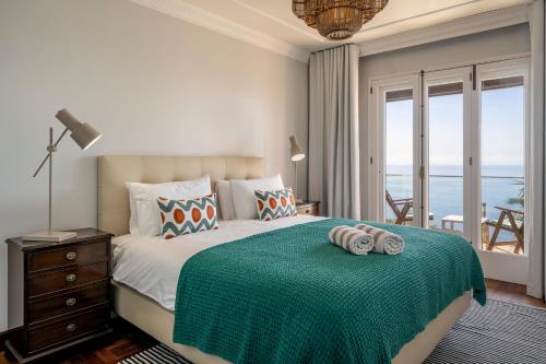a bedroom with a bed with a view of the ocean at OurMadeira - Vista Grande in Caniço