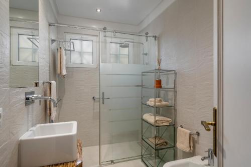 a bathroom with a shower and a sink and a mirror at OurMadeira - Vista Grande in Caniço