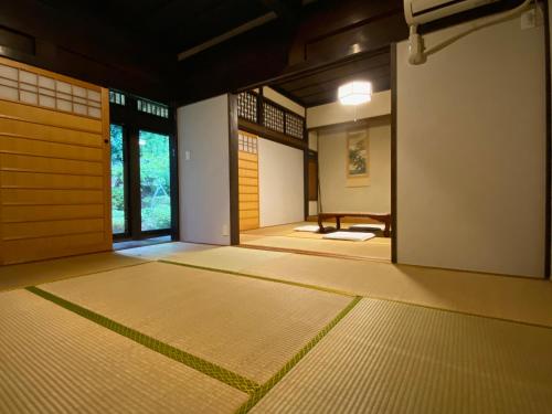 una habitación vacía con puerta y una habitación con esterillas en 農家民宿 山いちご, en Echizen