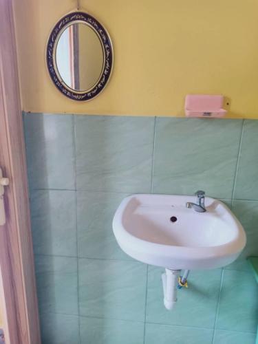 a bathroom with a sink and a mirror on the wall at Inap Desa 2 in Baling