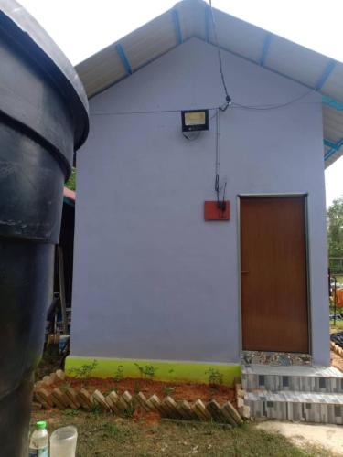 a blue building with a brown door on it at Inap Desa 2 in Baling
