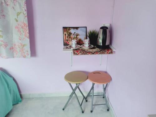 dos mesas de anidación en una habitación con una pared en Inap Desa 2, en Baling