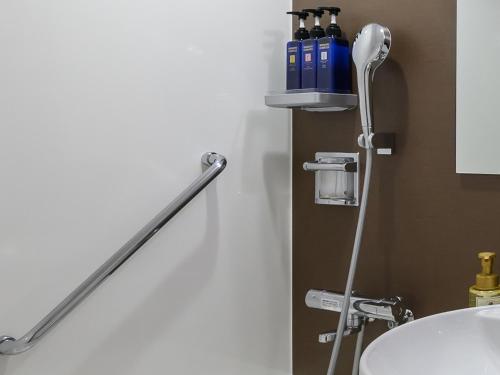 a bathroom with a towel rack next to a sink at Hotel Tsu Center Palace in Tsu