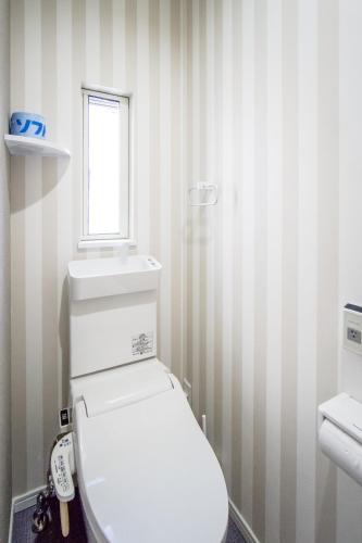 a bathroom with a white toilet and a window at HANASTAY花渓居 · 楓（KAEDE) in Osaka