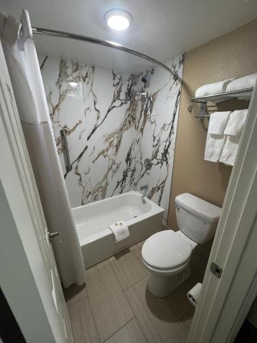 a bathroom with a toilet and a tub and a sink at Super 8 by Wyndham Paducah I-24 Exit 4 in Paducah