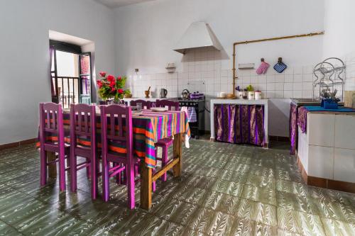 una cocina con mesa y algunas sillas moradas en Dragonfly Guest House en Sucre