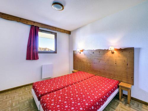 a bedroom with a red bed with a wooden headboard at Appartement Puy-Saint-Vincent, 2 pièces, 6 personnes - FR-1-330G-139 in Puy-Saint-Vincent