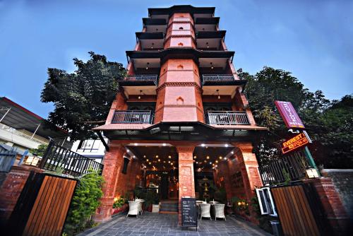 a large building with a tall tower with a patio at Everest Boutique Hotel in Kathmandu