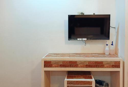 TV de pantalla plana colgada en la pared en Hotel Elinas and Restaurant en Tuguegarao