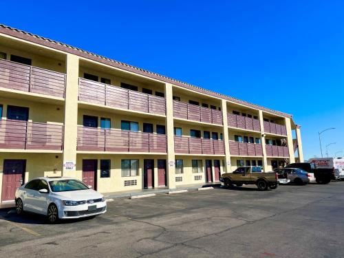 ein großes Gebäude mit Autos auf einem Parkplatz in der Unterkunft Highland Inn Las Vegas in Las Vegas