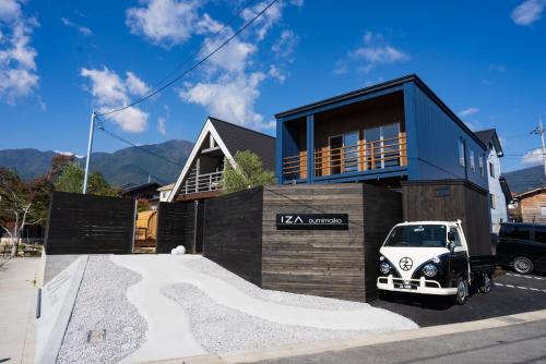 une petite voiture garée devant une maison dans l'établissement IZA近江舞子, à Minami-komatsu