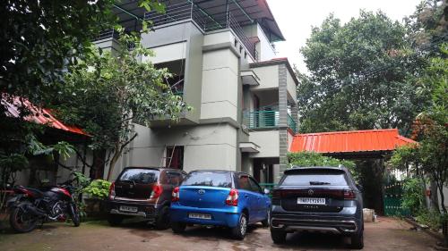 three cars parked in front of a building at Nakshatra Resort in Yelagiri