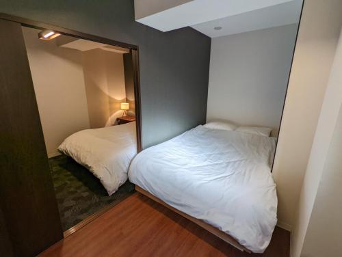 a small room with two beds and a mirror at Amber Iidabashi - Vacation STAY 87072v in Tokyo