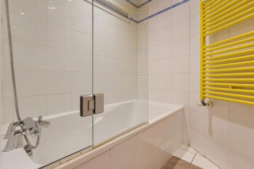 La salle de bains est pourvue d'une baignoire et d'une douche en verre. dans l'établissement La Ginabelle - Sauna & Swimming pool - Happy Rentals, à Chamonix-Mont-Blanc