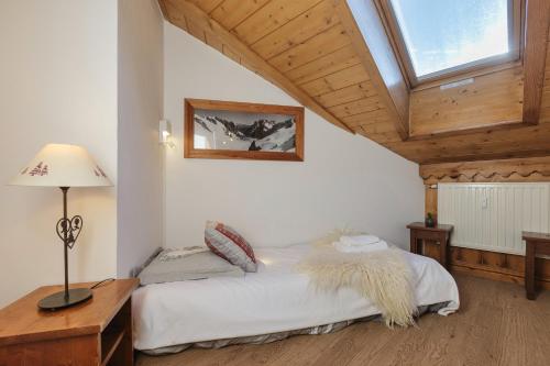 a bedroom with a bed and a wooden ceiling at La Ginabelle - Sauna & Swimming pool - Happy Rentals in Chamonix-Mont-Blanc