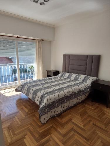 a bedroom with a bed and a large window at Casa en Mar del Plata in Mar del Plata