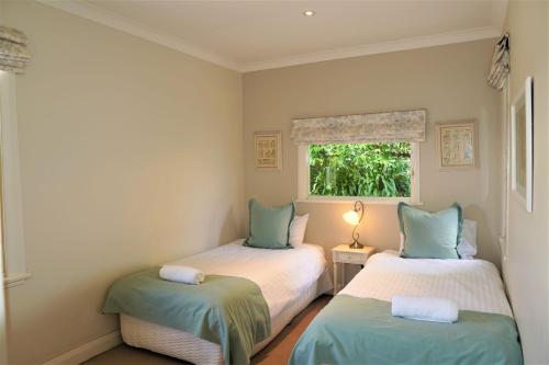 2 camas individuais num quarto com uma janela em Robin Hill Manor em Moss Vale
