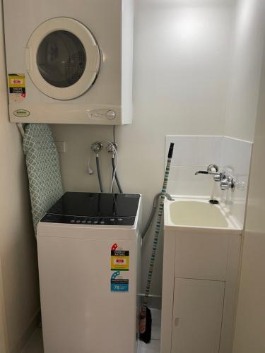 a small kitchen with a sink and a microwave at City Stadium Apartment on the Riverfront 38 in Townsville