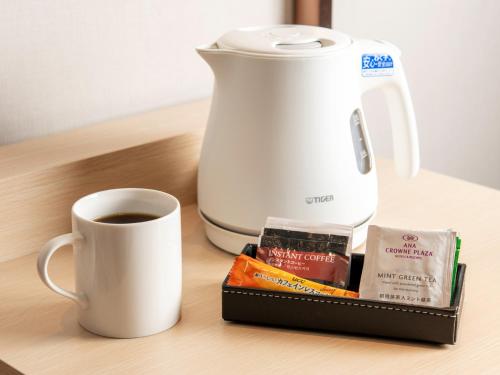 a coffee maker and a cup of coffee on a table at ANA Crowne Plaza Akita by IHG in Akita