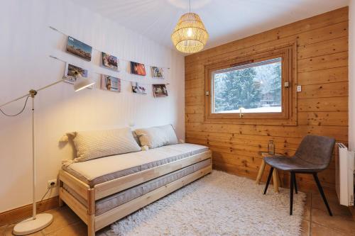 um quarto com uma cama, uma cadeira e uma janela em Cottage des Houches - Happy Rentals em Les Houches
