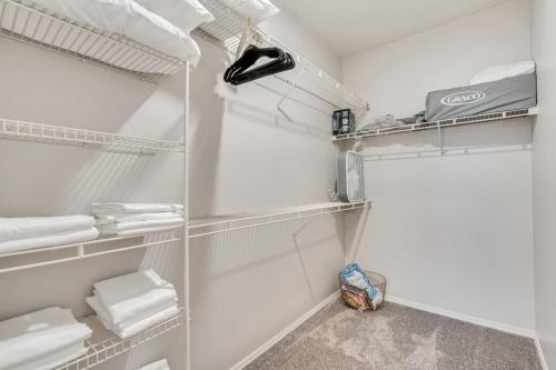 a white closet with white shelves and towels at 2 Jumbo King Beds w Pool 4K TVs Close to Hill AFB in Clearfield