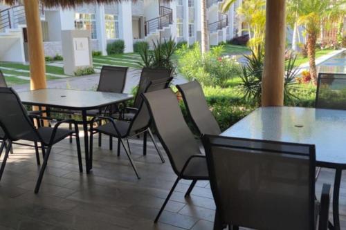 a patio with tables and chairs and a pool at DEPARTAMENTO con alberca in Manzanillo