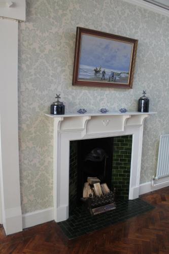 a living room with a fireplace with a picture on the wall at Riversdale Farm B&B in Ballinamore