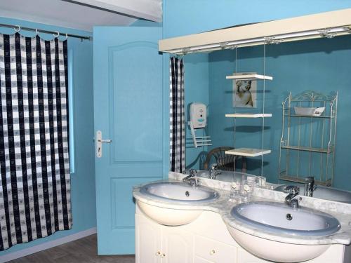 La salle de bains est pourvue de 2 lavabos et d'un mur bleu. dans l'établissement Maison à Perros-Guirec avec jardin, cour, cheminée, WIFI et proche du port de Ploumanac'h - FR-1-368-62, à Perros-Guirec