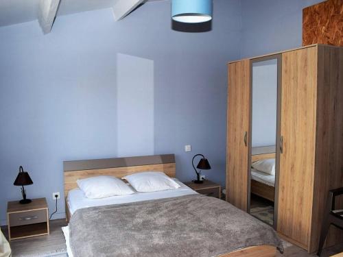 une chambre avec un grand lit et un miroir dans l'établissement Maison à Perros-Guirec avec jardin, cour, cheminée, WIFI et proche du port de Ploumanac'h - FR-1-368-62, à Perros-Guirec