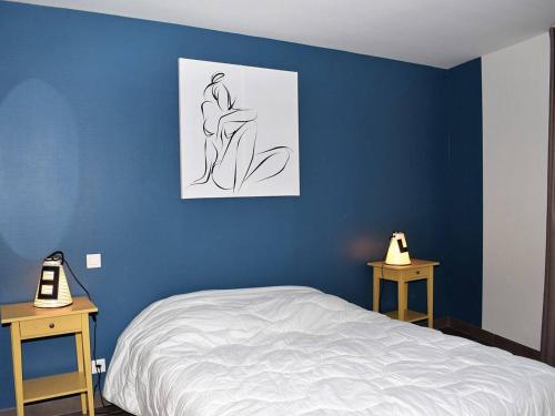 a bedroom with a blue wall with a bed and two tables at Maison Trégastel, 3 pièces, 4 personnes - FR-1-368-72 in Trégastel