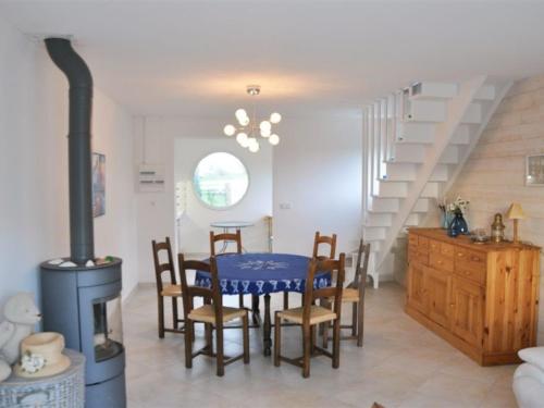 une salle à manger avec une table, des chaises et un poêle dans l'établissement Maison moderne à 100m de la plage à Trégastel - FR-1-368-203, à Trégastel