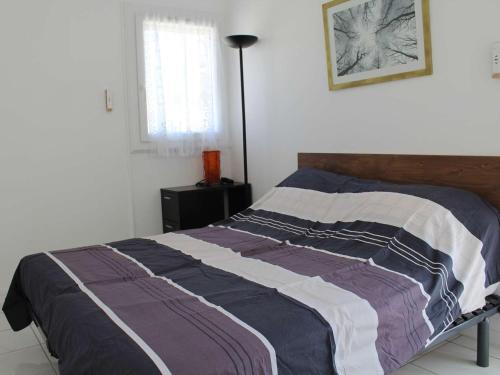 une chambre avec un lit avec une couverture dessus dans l'établissement Maison familiale rénovée, à 100m de la plage, terrasse, garage, wifi, au centre de Port-la-Nouvelle - FR-1-229C-51, à Port-la-Nouvelle