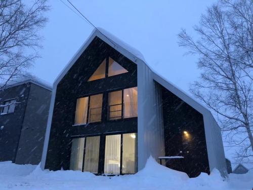 a house in the snow at night at Niseko White Villas YUNOSATO in Rankoshi