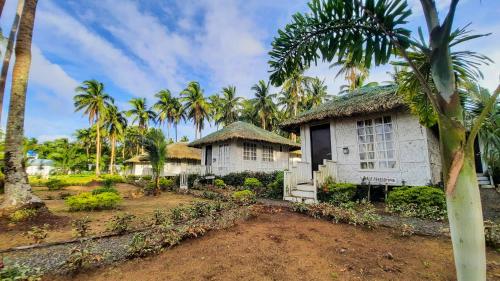 un par de casas blancas con palmeras en Kehalani Beach Resort by Cocotel en Quezon