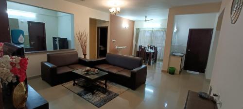 バンガロールにあるBulande Comforts-Service Apartment ITPL Whitefieldのリビングルーム(ソファ、コーヒーテーブル付)
