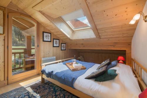 ein Schlafzimmer mit einem Bett in einer Holzhütte in der Unterkunft Chalets d'en haut - Zaria - Happy Rentals in Argentières