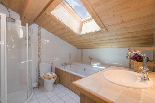 ein Badezimmer mit einer Badewanne, einem Waschbecken und einem WC in der Unterkunft Chalets d'en haut - Zaria - Happy Rentals in Argentières