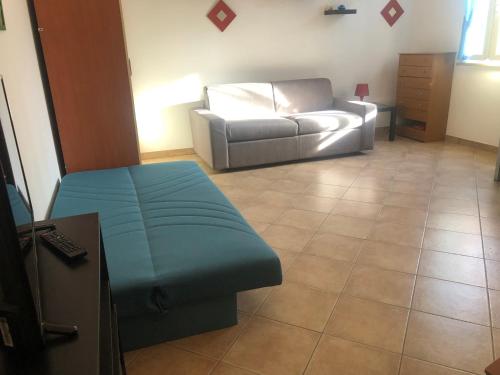 a living room with a couch and a chair at Liana monolocale in San Vincenzo