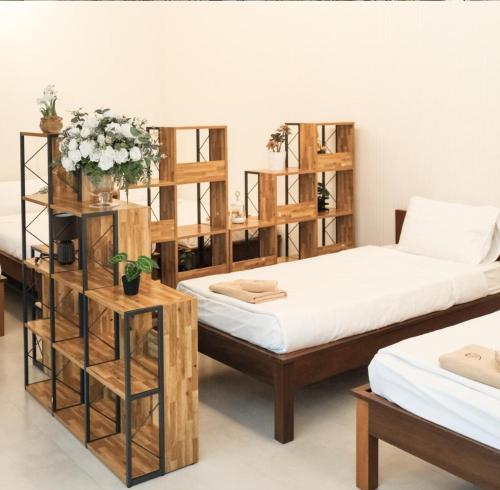 two beds in a room with wooden shelves at Ravin Home ราวินโฮม in Nakhon Nayok