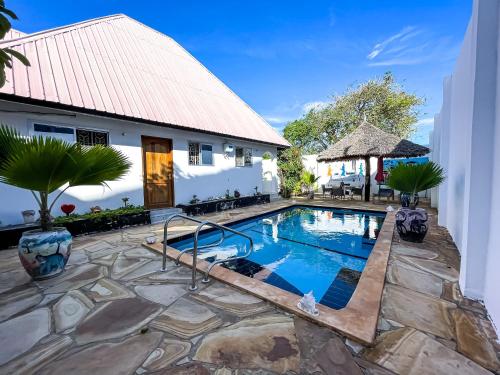 uma piscina em frente a uma casa em Daniel Zanzibar Hotel em Nungwi