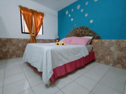 a bedroom with a bed with pink pillows at House Jardin Del Caribe in Las Terrenas