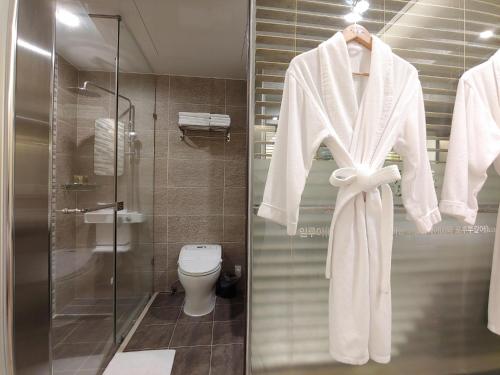 - Baño con aseo y perchero con albornoz en Jeju Irrua Hotel en Jeju