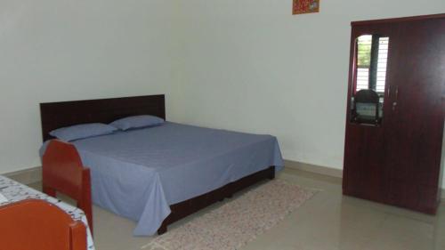 a bedroom with a bed and a window and a door at Shree Raksha Homestay in Gonikoppal