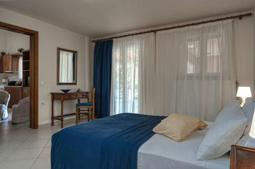 a bedroom with a bed with a blue blanket on it at Alice Happy place 1 , only 5 minutes from the shipwreck!!! in Anafonítria